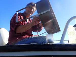 Greg Ruiz on boat with sediment sifter