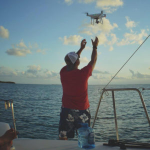 Man on boat sending up drone