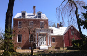 18th-century red brick house surrounded by trees