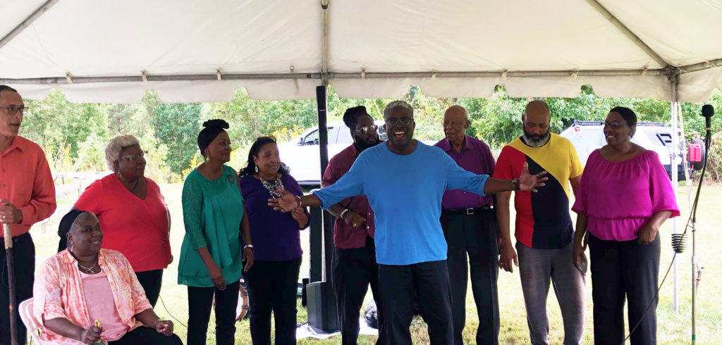 African-American choir singing underneath a tent outside